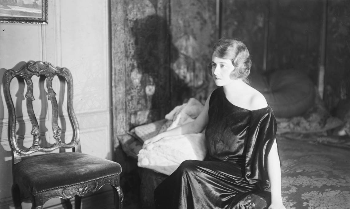 Mme Piérat, assise sur le bord d'un lit, dans une chambre, Agence Rol, 1923 - source : Gallica-BnF