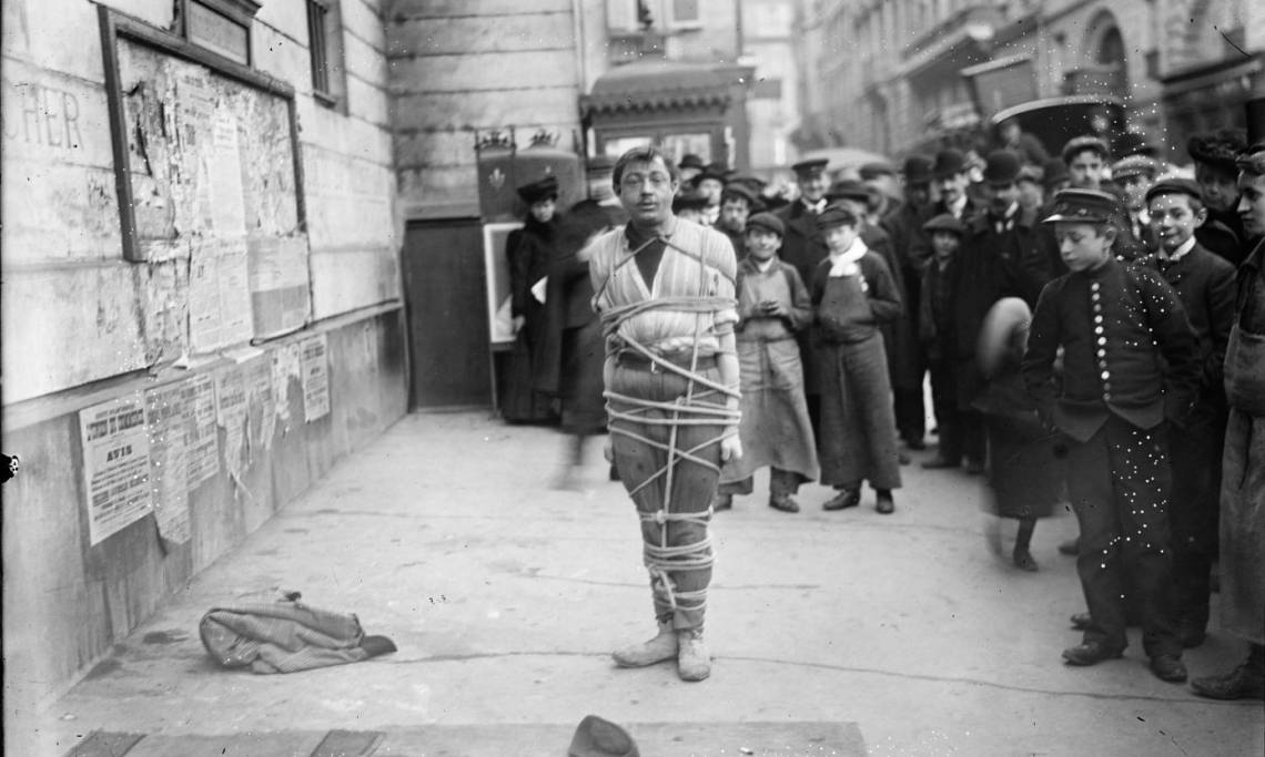 Prestidigitateur ligoté dans une rue de Paris, Agence Rol, circa 1904 – source : Gallica-BnF