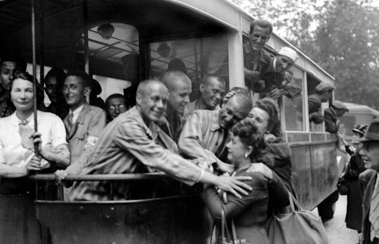 Des déportés français en Allemagne, portant encore l’uniforme rayé du camp de concentration, sont accueillis par des Parisiens à leur arrivée au centre de l’hôtel Lutétia, en mai 1945 - source : AFP 